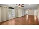 Bright living room featuring wood floors, neutral paint, a ceiling fan, and a large window with natural light at 7296 Sw 115Th Pl, Ocala, FL 34476