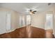 Inviting living room showcasing wood floors, neutral walls, a ceiling fan, and views into the kitchen and bathroom at 7296 Sw 115Th Pl, Ocala, FL 34476