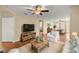 Comfortable living room showcasing wood floors, neutral paint, and an open layout to the dining and kitchen areas at 7296 Sw 115Th Pl, Ocala, FL 34476