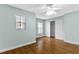 Bright bedroom featuring hardwood floors, a ceiling fan, and closet space at 7614 Acklins Rd, Kissimmee, FL 34747