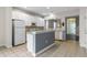 Well-lit kitchen featuring white cabinetry, tile floors, and a functional breakfast bar at 7614 Acklins Rd, Kissimmee, FL 34747