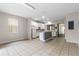 Open-concept living area featuring tile flooring, white cabinets, and kitchen island at 7614 Acklins Rd, Kissimmee, FL 34747