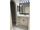 Renovated bathroom featuring modern vanity with drawers, white marble countertop, and framed mirror at 7727 Harbor Lake Dr, Orlando, FL 32822