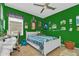 A bedroom with light green walls, white trim, and a ceiling fan with natural light at 824 Preserve Ter, Lake Mary, FL 32746