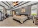 Serene main bedroom with a tray ceiling, plush carpeting, and ample natural light from large windows at 824 Preserve Ter, Lake Mary, FL 32746