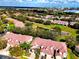 Aerial view exhibits homes near a pond with a fountain, lush landscaping, and a scenic lakeside community at 8443 Via Bella Notte, Orlando, FL 32836