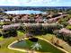 Aerial view showcases homes near a pond with a fountain, lush landscaping, and a scenic lakeside community at 8443 Via Bella Notte, Orlando, FL 32836