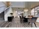 Open dining area with modern chandelier, gray flooring, leading into the kitchen with white cabinets at 8443 Via Bella Notte, Orlando, FL 32836