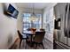 A modern dining area with a dark wood table, four chairs, and a window at 8443 Via Bella Notte, Orlando, FL 32836