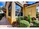 Sunny view of the corner of a house with a brick walkway and well manicured bushes at 8443 Via Bella Notte, Orlando, FL 32836