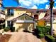 A sunny shot of this house with an attached garage and paved driveway and a red tile roof at 8443 Via Bella Notte, Orlando, FL 32836