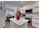 A chef's kitchen with modern stainless steel appliances, white cabinets and white island at 8443 Via Bella Notte, Orlando, FL 32836