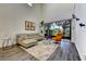 A shot of a modern living room with sliding glass doors, gray floors and climbing wall art at 8443 Via Bella Notte, Orlando, FL 32836