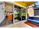 View of a screened patio featuring sliding glass doors, comfortable seating, and neutral-toned tile flooring at 8443 Via Bella Notte, Orlando, FL 32836