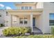 Inviting front porch featuring a blue door, white columns, and well-maintained landscaping at 9014 Sonoma Coast Dr, Winter Garden, FL 34787