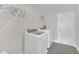 Functional laundry room featuring a washer and dryer, shelving, and modern tile flooring at 9014 Sonoma Coast Dr, Winter Garden, FL 34787