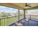 Screened patio featuring dark wood floors, wicker furniture, and a view of the lake at 9014 Sonoma Coast Dr, Winter Garden, FL 34787