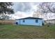 View of the backyard with a house, a fence and some trees under a cloudy sky at 913 Lake Ave, Edgewater, FL 32132