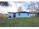 View of the backyard with a house, a door, and some trees under a cloudy sky at 913 Lake Ave, Edgewater, FL 32132