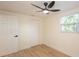 This bedroom features wood floors, modern ceiling fan, closet, window and neutral paint at 913 Lake Ave, Edgewater, FL 32132