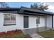 Close up of a Charming single-story home with a well-manicured front yard and a gray concrete walkway leading to the front door at 913 Lake Ave, Edgewater, FL 32132