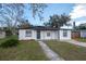 Charming single-story home with a well-manicured front yard and a gray concrete walkway leading to the front door at 913 Lake Ave, Edgewater, FL 32132