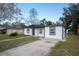 Charming single-story home with a well-manicured front yard and a gray concrete driveway leading to the front door at 913 Lake Ave, Edgewater, FL 32132