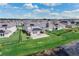 Aerial view of homes with solar panels in a Primary planned community with a pond and landscaping at 9752 Petition Way, Orlando, FL 32832