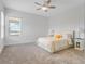 Airy bedroom with plush carpet, large window, ceiling fan, and bedside tables at 9752 Petition Way, Orlando, FL 32832