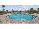 A beautiful community pool featuring a beach entry, palm trees, splash pad, and sand volleyball at 9752 Petition Way, Orlando, FL 32832