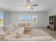 Open concept living room featuring a large sectional sofa, a ceiling fan and large windows with tranquil views at 9752 Petition Way, Orlando, FL 32832