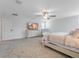 This main bedroom boasts neutral colors, a ceiling fan, and a dresser with a TV at 9752 Petition Way, Orlando, FL 32832