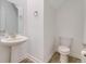 A tidy half bathroom features a pedestal sink, toilet, and tile floor at 9752 Petition Way, Orlando, FL 32832