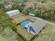 Aerial view of the property featuring a fenced pool, large workshop and lush greenery at 1134 Glenwood Rd, Deland, FL 32720