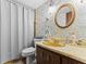 Quaint bathroom with a decorative mirror and wallpaper at 1134 Glenwood Rd, Deland, FL 32720