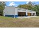 Three-bay metal building showcasing open garage doors, revealing storage and workshop potential at 1134 Glenwood Rd, Deland, FL 32720