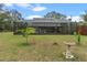 Screened-in pool connected to the home, overlooking a garden with a birdbath, creating a peaceful backyard retreat at 1134 Glenwood Rd, Deland, FL 32720