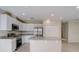 Bright kitchen featuring white cabinetry, stainless steel appliances, and a granite island at 124 Appian Way, Kissimmee, FL 34758