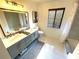 Bright bathroom featuring a double sink vanity, a framed mirror, a toilet, and a window at 124 Godfrey Rd, Edgewater, FL 32141