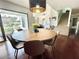 Bright dining area with a modern light fixture and sliding glass doors that lead to the deck at 124 Godfrey Rd, Edgewater, FL 32141