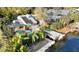 Waterfront home featuring a screened-in pool, boat lift, and lush tropical landscaping at 124 Godfrey Rd, Edgewater, FL 32141
