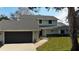 Charming two-story home featuring a gray roof and light green siding with a two car garage at 124 Godfrey Rd, Edgewater, FL 32141