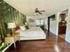 Serene main bedroom with a forest-themed wallpaper accent wall, ceiling fan, and ensuite bathroom access at 124 Godfrey Rd, Edgewater, FL 32141