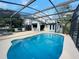 Sparkling pool enclosed in a screened lanai, complete with a convenient bar area for seamless indoor-outdoor entertaining at 124 Godfrey Rd, Edgewater, FL 32141