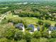 Aerial view of real estate nestled on a golf course among lush greenery and neighboring houses at 1312 Winter Springs Blvd, Winter Springs, FL 32708