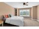 Spacious bedroom featuring a ceiling fan, a large window, built-in shelving, and neutral walls at 1312 Winter Springs Blvd, Winter Springs, FL 32708