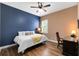 Tastefully decorated bedroom featuring a blue accent wall, wood-look floors, and a ceiling fan at 1312 Winter Springs Blvd, Winter Springs, FL 32708