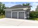 Three-car garage featuring matching gray doors with decorative windows and custom lighting at 1312 Winter Springs Blvd, Winter Springs, FL 32708