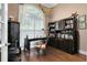 Cozy home office featuring wood floors, built-in cabinets, and a large window with plantation shutters at 1312 Winter Springs Blvd, Winter Springs, FL 32708