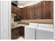 This laundry room offers wood cabinets, front loading washer and dryer, and a sink for added convenience at 1312 Winter Springs Blvd, Winter Springs, FL 32708